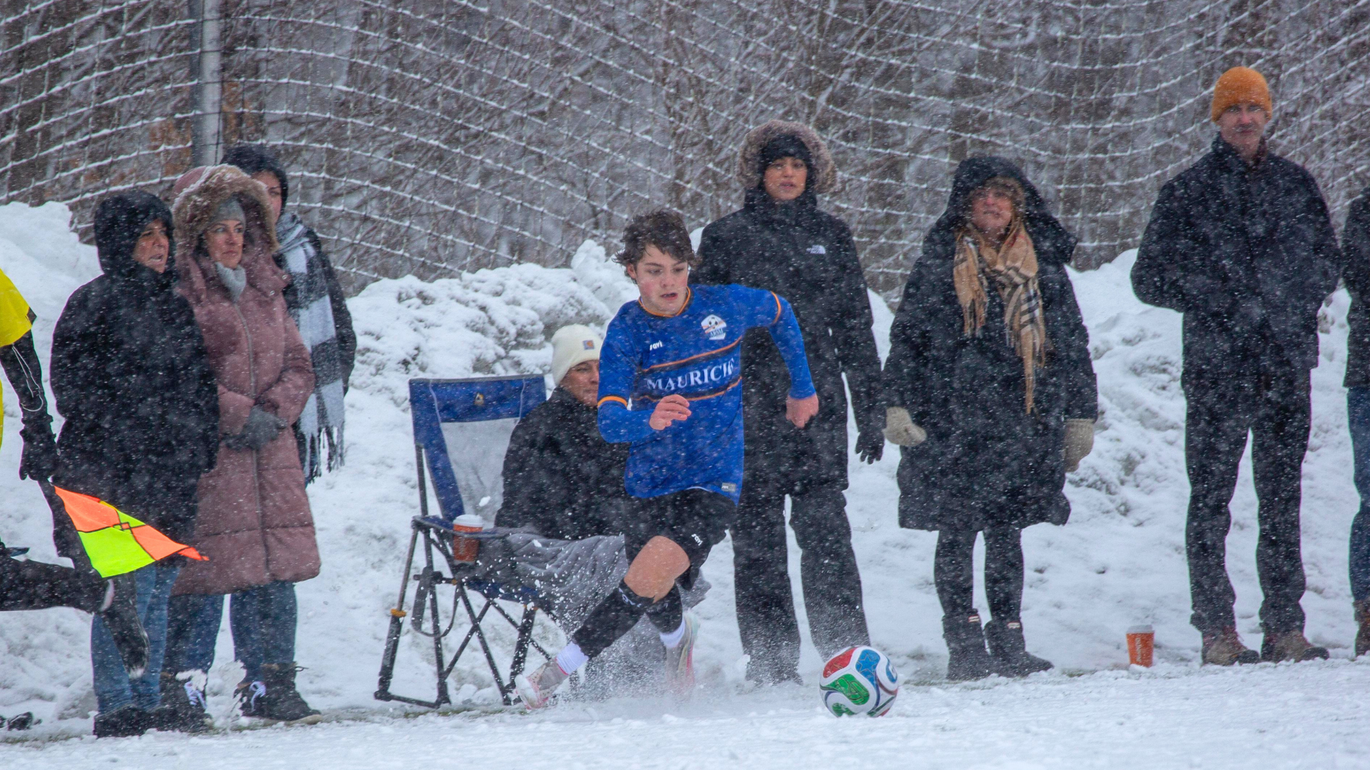 Boy playing soccer in the snow
